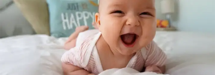 Chiropractic Cape Coral FL Pediatric Chiropractic Baby laying on its tummy, with a big gummy smile