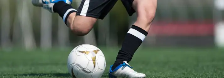 Chiropractic Cape Coral FLChiropractic For Athletes a A pair of legs about to kick a soccer ball
